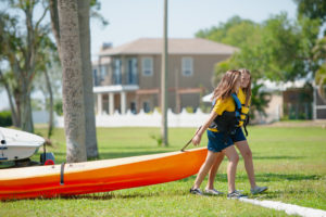 Admiral Farragut Academy waterfront girls walking with kayak